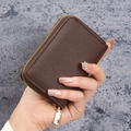 Dark brown pebble leather card wallet with gold zipper closure held in hand - Dark Coffee