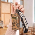 Brown leather mini pouch with bear print and silk scarf keychain on hand - Brown