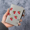 Light gray leather wallet with red cherry embroidery and zipper closure in hand - Gray