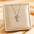 Elegante collana con ciondolo a fiocco argento e cristalli lucidi su sfondo di seta - Fiocco Argentato (8547)