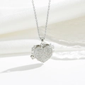 Macro shot of silver heart locket necklace with pavé cubic zirconia on silk fabric - Openable Style / Silver White Zircon (8759)