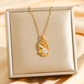 Collana dorata con pendente geometrico irregolare, texture foglia e cristalli scintillanti - Ovale irregolare