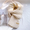 Detail of chunky knit scarf texture with a handmade leather tag on a soft fabric background - 40x190cm / Beige