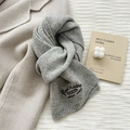Close-up of grey knit wool scarf featuring brown Berchoise letter embroidery detail - Gray