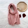 Soft pink cashmere-feel scarf with fringe edges displayed on a white fabric background - Pure Pink