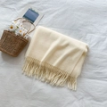 Morbida sciarpa color crema effetto cashmere con eleganti nappe su un letto accogliente - Bianco Sporco
