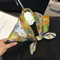 Silk neckerchief in yellow and orange cactus print tied as a bow on a black knit top - 53x53cm / Strange World