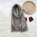 Solid medium grey cashmere-like scarf with short fringes on white textured fabric - Light Gray
