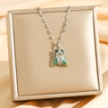 Détail macro du pendentif cigale avec ailes en émail vert et yeux émeraude sur écrin doré - Design Cigale (8786 Argent Style 2) / Argent