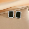 Détails macro de boucles d'oreilles noires rectangulaires serties de zircons - Boucles d'Oreilles Clous Rectangulaires Argentées