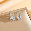 Macro shot of silver letter H earrings with sparkling round zircon studs on champagne silk - Silver Stud Earrings