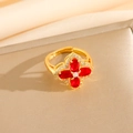 Macro shot of gold floral open ring featuring red oval gemstones and pavé crystals - Red Zircon Clover Ring (Adjustable Open) (8460)