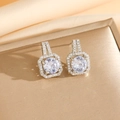 Détail des boucles d'oreilles halo avec zircone cubique ronde sur fond satiné - Boucles d'Oreilles Puces en Argent