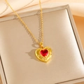 Gros plan du collier coeur plaqué or avec pierre rouge facettée et détails de motifs gravés - Collier Coeur Rouge Doré (8458)