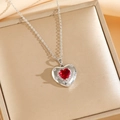 Détail du collier avec pendentif cœur rouge sur un coffret à bijoux doré de luxe - Collier Coeur Rouge Argenté (8458)