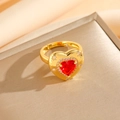 Détail macro d'une bague en zircon rouge en forme de cœur avec gravure d'étoile dorée - Bague Coeur Rouge Doré (8458)