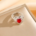 Détail d'une bague coeur argentée avec une pierre rouge centrale et motifs d'étoiles - Bague Coeur Rouge Argenté (8458)