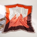 Elegant silk scarf featuring geometric orange and brown patterns on a satin surface - Patchwork Moon Orange