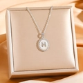 Macro view of silver H letter pendant with shell inlay on a jewelry box background - Silver White Shell H(8832)