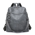 Minimalist grey faux leather backpack with woven strap and decorative pendant detail - Gray