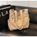 Dettaglio della borsa tote in velluto a coste crema con tasca con zip e trama a costine - Bianco