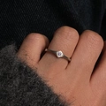 Mattsilberner Sternring mit violettem Edelstein an der Hand auf grauem Strickhintergrund - Lila achtzackiger Stern gebürsteter Ring (verstellbar)