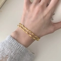 Golden double-layer irregular wavy open cuff bracelets worn on a model wrist - Double Layer Twisted Wave Style / Gold