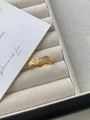 Dettaglio dell'anello dorato con design a moneta e zirconi bianchi su tessuto - Anello Zirconia Moneta d'Oro