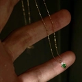 Dettaglio di una delicata collana dorata con ciondolo in zircone verde smeraldo a triangolo - Collana Piccola con Zircone Triangolare