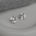 Elegant zircon pearl flower earrings in silver finish on a minimalist ceramic plate - Zirconia Pearl Flower Studs