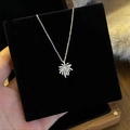 Elegante zilveren bloemenketting met glinsterende zirkonia op een zwarte sieradenhouder - Zilveren Vuurwerk Stijl