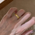 Elegante anello dorato con texture a onde e piccoli strass al dito da donna - Anello con Elefante d'Oro