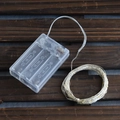Warm white LED string lights with transparent battery box on dark wood background - 5m Warm White