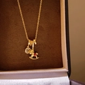 Gouden ketting met micro-geplaveide ring en schommelpaard hanger met rode accenten - Ring Paard Hanger Ketting