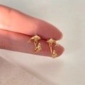 Gedetailleerde macro-opname van gouden dolfijn oorbellen met gepolijste spiegelglans - Goud