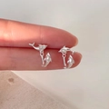 Gedetailleerde macro-opname van zilveren dolfijn oorknopjes met een minimalistisch 3D-ontwerp - Zilver