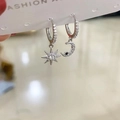 Close-up of asymmetric s925 silver earrings with pavé zircon star and crescent moon pendants - White Gold Pave Zirconia Asymmetric Star Moon