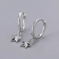 Macro detail of S925 sterling silver hoop earrings with star pendants and mirror polish - 3D Star Earrings - Silver