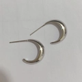 Macro-opname van gepolijste S925 sterling zilveren halve maan oorbellen met glinstereffect - Zilver
