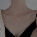 Elegante collana con ciondolo a onda in oro rosa e cristalli sulla clavicola della donna - Stile a Onda / Oro rosa