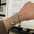 Retro Silber-Herz-Armband mit OT-Verschluss, getragen in einem stilvollen Café-Ambiente - Vintage Herz Armband