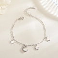 Dettaglio di ciondoli a stella e luna in argento S925 su una delicata catena a maglie - Bracciale Stella e Luna