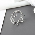 Elegante anillo abierto con corazones calados en acabado plateado y diseño minimalista para mujer - Abierto Ajustable / Plateado