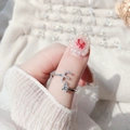 Close-up of adjustable letter E silver ring with white zircon stones on a woman's finger - Letter E