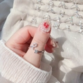 Macro shot of silver letter P ring with pavé crystals and square cubic zirconia on hand - Letter P