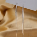 Close-up of sparkling long tassel earrings with pavé zircons on elegant champagne silk - White Gold