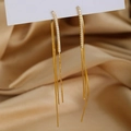 Macro detail of long gold tassel earrings with shimmering crystals on silk background - Gold