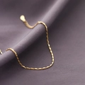 Macro shot of minimalist gold geometric rectangular chain links on purple velvet fabric - Gold