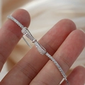 Macro detail of S925 silver bow bracelet featuring micro-pave cubic zirconia stones - Silver Bow Zirconia Bracelet