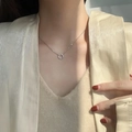 Detailopname van minimalistische zilveren ringketting met microdiamanten op sleutelbeen - Witgoud